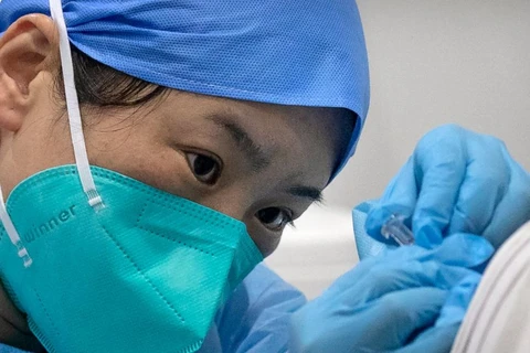 Nhân viên y tế tiêm vaccine ngừa COVID-19 cho một bệnh nhân tại một cơ sở tiêm chủng ở Bắc Kinh. (Nguồn: AP)