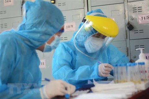 Các nhân viên y tế làm xét nghiệm SARS-CoV-2. (Nguồn: TTXVN)