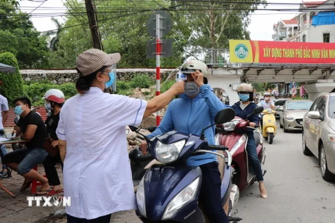 Lực lượng chức năng làm nhiệm vụ tại chốt kiểm soát dịch bệnh ở cầu Y Na, phường Kinh Bắc, thành phố Bắc Ninh. (Ảnh: Thanh Thương/TTXVN)