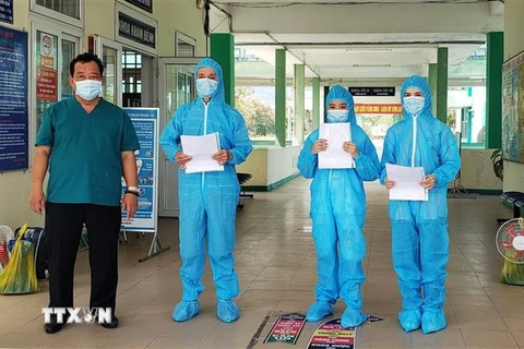 Bác sỹ Lê Thành Phúc trao giấy chứng nhận khỏi bệnh cho BN3396, BN3397, BN3398. (Ảnh: Văn Dũng/TTXVN)