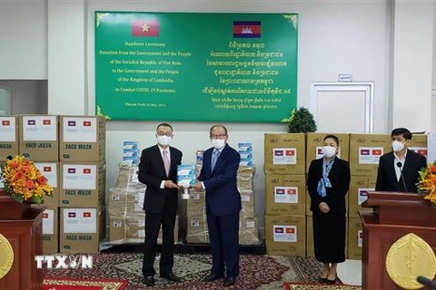 Đại sứ Vũ Quang Minh đại diện Việt Nam (trái) bàn giao máy thở, vật tư y tế hỗ trợ Campuchia chống dịch COVID-19 cho Bộ trưởng Bộ Y tế Campuchia. (Ảnh: Nguyễn Vũ Hùng/TTXVN)
