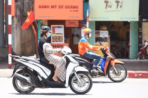 Người dân che, chắn trong đợt nắng nóng cục bộ tại Hà Nội. (Ảnh: Hoàng Hiếu/TTXVN)