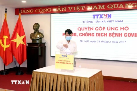 Tổng Giám đốc TTXVN Nguyễn Đức Lợi quyên góp, ủng hộ Quỹ phòng, chống dịch COVID-19. (Ảnh: Phạm Kiên/TTXVN)