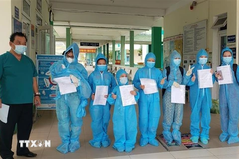 Giám đốc Bệnh viện Phổi Đà Nẵng trao giấy chứng nhận khỏi bệnh và xuất viện cho các bệnh nhân mắc COVID-19. (Ảnh: Văn Dũng/TTXVN)