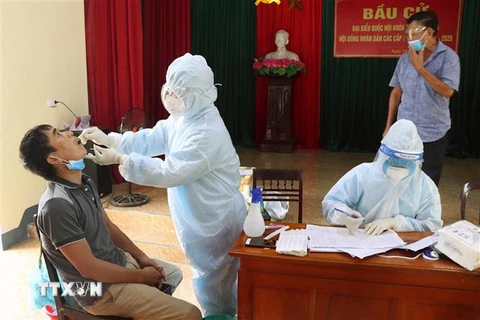 Cán bộ y tế lấy mẫu bệnh phẩm cho người dân ở thành phố Hà Tĩnh. (Ảnh Công Tường/TTXVN)
