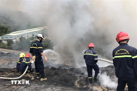 Các chiến sỹ phòng cháy chữa cháy dập lửa ở khu vực bãi rác Khánh Sơn. (Ảnh: Quốc Dũng/TTXVN)