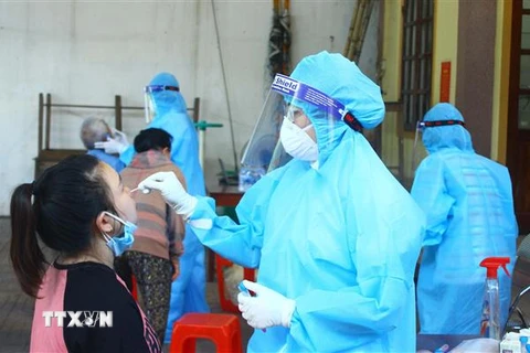 Cán bộ y tế lấy mẫu xét nghiệm cho người dân phường Hà Huy Tập, thành phố Vinh, tỉnh Nghệ An. (Ảnh: Tá Chuyên/TTXVN)