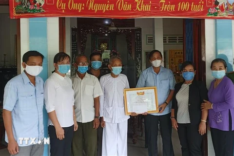 Cụ ông Nguyễn Văn Khai (thứ 5 từ trái sang) đã đóng góp tiền tiết kiệm cho Quỹ phòng, chống dịch bệnh COVID-19 và được lãnh đạo Ủy ban MTTQ Việt Nam tỉnh Đồng Tháp đến trao Bằng khen. (Ảnh: TTXVN phát)