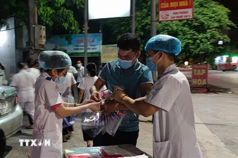 Lực lượng y, bác sỹ Nghệ An lấy mẫu xét nghiệm virus SARS-CoV-2 cho F1 của bệnh nhân 11634 trong đêm 16/6. (Ảnh: Văn Tý/TTXVN)