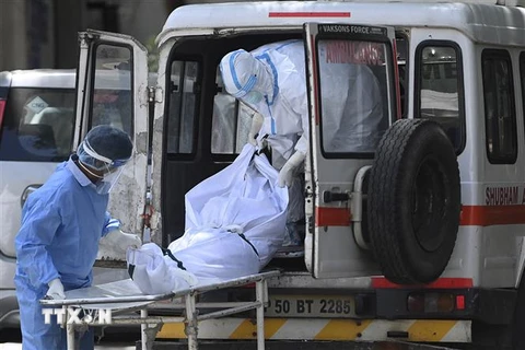 Nhân viên y tế chuyển bệnh nhân tử vong do COVID-19 tới nhà xác ở New Delhi, Ấn Độ. (Ảnh: AFP/TTXVN)