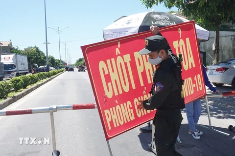 Cảnh sát cơ động làm nhiệm vụ trực chốt tại Quốc lộ 46 đoạn tiếp giáp giữa xã Hưng Chính (thành phố Vinh) và Khu công nghiệp VSIP (huyện Hưng Nguyên). (Ảnh: Bích Huệ/TTXVN)