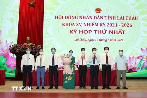  Phó Bí thư Thường trực Tỉnh ủy Lê Văn Lương tặng hoa chúc mừng Chủ tịch Hội đồng nhân dân Giàng Páo Mỷ cùng các lãnh đạo chủ chốt của Hội đồng Nhân dân tỉnh Lai Châu khóa XV, nhiệm kỳ 2021-2026. (Ảnh: Quý Trung/TTXVN)