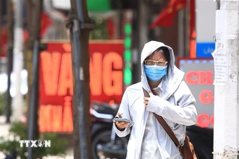 Người đi bộ khó chịu với thời tiết trong đợt nắng nóng tại Hà Nội. (Ảnh: Hoàng Hiếu/TTXVN)