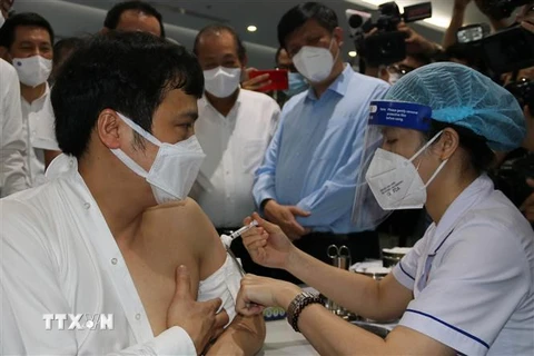 Phó Thủ tướng Thường trực Chính phủ Trương Hòa Bình kiểm tra việc tiêm chủng vaccine phòng COVID-19 tại Công ty trách nhiệm hữu hạn phần mềm FPT, Thành phố Hồ Chí Minh. (Ảnh: Thanh Vũ/TTXVN)