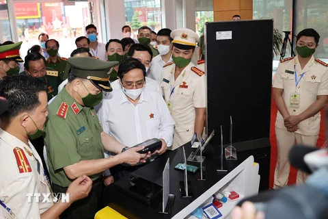 Thủ tướng Chính phủ Phạm Minh Chính tham quan khu vực trưng bày các trang thiết bị phục vụ Dự án Cơ sở dữ liệu quốc gia về dân cư. (Ảnh: Dương Giang/TTXVN)