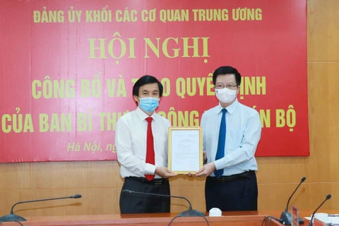 Ông Mai Văn Chính, Phó Trưởng ban Tổ chức Trung ương trao quyết định của Ban Bí thư cho ông Nguyễn Quang Trường. (Ảnh: Phương Hoa/TTXVN)