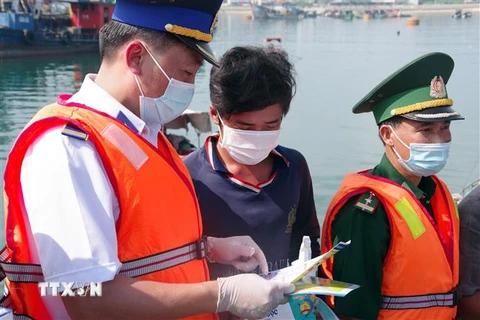 Cảnh sát biển tuyên truyền cho bà con ngư dân tại đảo Bạch Long Vỹ. (Ảnh: TTXVN)