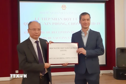 Đại sứ đặc mệnh toàn quyền Việt Nam tại Pháp Đinh Toàn Thắng tiếp nhận tiền ủng hộ của Hội người Việt Nam tại Pháp. (Ảnh: TTXVN)