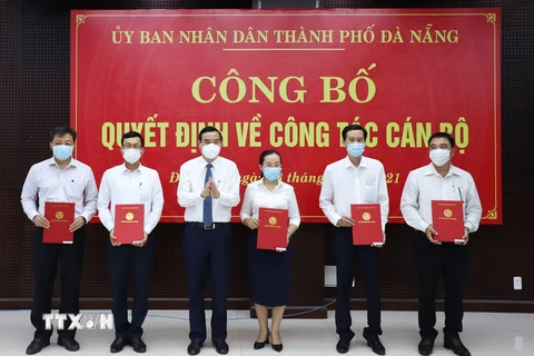 Chủ tịch UBND thành phố Đà Nẵng Lê Trung Chinh (thứ 3 từ trái sang) trao quyết định điều động cho các cán bộ. (Ảnh: TTXVN phát)