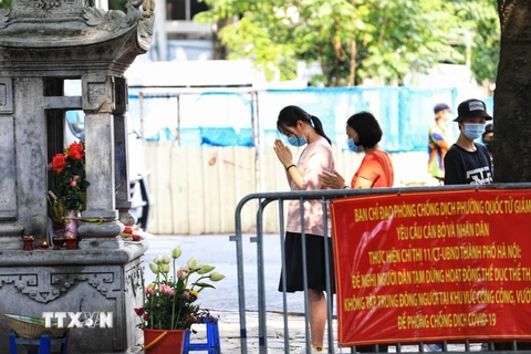 Trước cửa Văn Miếu, phụ huynh và các sỹ tử đến lễ khá đông dù đã có thông báo của Ban Chỉ đạo phòng, chống dịch COVID-19 phường Quốc Tử Giám. (Ảnh: Thành Đạt/TTXVN)