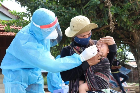 Lực lượng y tế lẫy mẫu xét nghiệm cho em bé người đồng bào dân tộc thiểu số buôn Ly, xã Ea Trol (Sông Hinh, Phú Yên). (Ảnh: Phạm Cường/TTXVN)