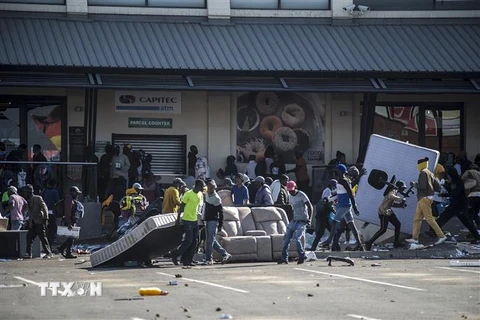Các đối tượng cướp phá tại một cửa hàng ở Johannesburg, Nam Phi ngày 12/7/2021. (Ảnh: AFP/TTXVN)