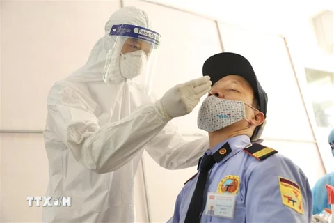 Nhân viên y tế phường Thượng Đình (quận Thanh Xuân) lấy mẫu xét nghiệm cho người có nguy cơ cao trên địa bàn. (Ảnh: Minh Quyết/TTXVN)