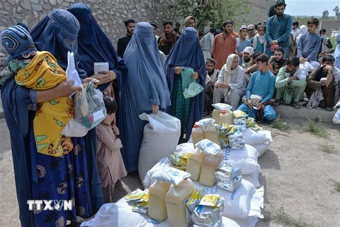 Phụ nữ nhận lương thực cứu trợ tại Jalalabad, Afghanistan, ngày 20/4/2021. (Ảnh: AFP/TTXVN)