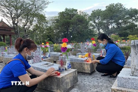 Các đoàn viên, thanh niên thắp nến tại các khu mộ ở Nghĩa trang Liệt sỹ Quốc gia Trường Sơn. (Ảnh: Thanh Thủy/TTXVN)