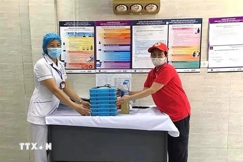 Hội Chữ thập Đỏ quận Tây Hồ, Hà Nội tặng bữa ăn trưa, ăn tối cho các y bác sỹ đang làm nhiệm vụ và hỗ trợ người dân bị ảnh hưởng bởi dịch. (Ảnh: TTXVN phát)