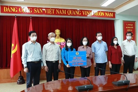 Trưởng ban Tổ chức Trung ương Trương Thị Mai trao biểu trưng hỗ trợ 100.000 suất quà cho công nhân lao động khu vực bị cách ly, phong toả tỉnh Đồng Nai. (Nguồn: Dangcongsan.vn)