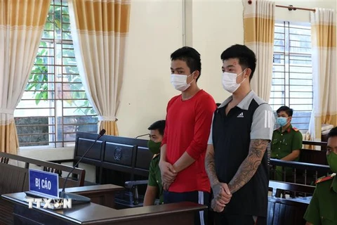 Hai bị cáo Nguyễn Hữu Tài và Phạm Nhật Quang tại tòa. (Ảnh: TTXVN phát)