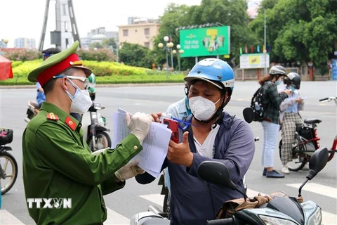 Lực lượng chức năng hỗ trợ người dân thực hiện khai báo thông tin di biến động trên đường Điện Biên Phủ, quận Bình Thạnh, Thành phố Hồ Chí Minh. (Ảnh: Thanh Vũ/TTXVN)