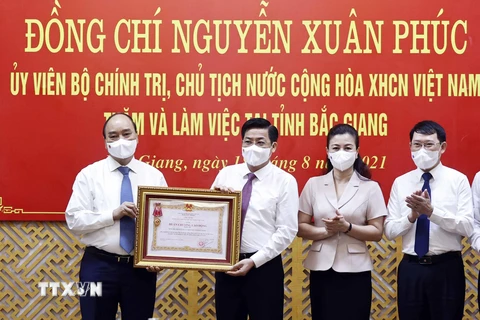 Chủ tịch nước Nguyễn Xuân Phúc trao Huân chương Lao động hạng Ba cho Đảng bộ, chính quyền và nhân dân tỉnh Bắc Giang. (Ảnh: Thống Nhất/TTXVN)