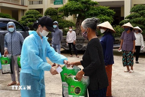 Trao tặng quà cho các hộ nghèo, hộ cận nghèo, người có hoàn cảnh khó khăn... tại phường Biên Giang, quận Hà Đông. (Ảnh: Tuấn Anh/TTXVN)