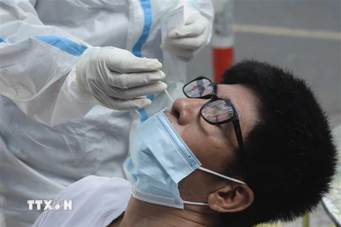 Nhân viên y tế lấy mẫu xét nghiệm cho người dân Đà Nẵng. (Ảnh: Văn Dũng/TTXVN)