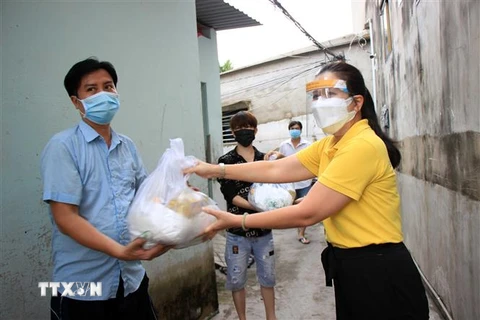Trao tặng quà cho lao động nghèo, gặp khó khăn do ảnh hưởng dịch bệnh COVID-19 tại phường Hiệp Thành, quận 12, Thành phố Hồ Chí Minh. (Ảnh: Xuân Khu/TTXVN)