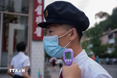 Đo thân nhiệt nhằm ngăn chặn sự lây lan của dịch COVID-19 tại Bình Nhưỡng, Triều Tiên. (Ảnh: AFP/TTXVN)