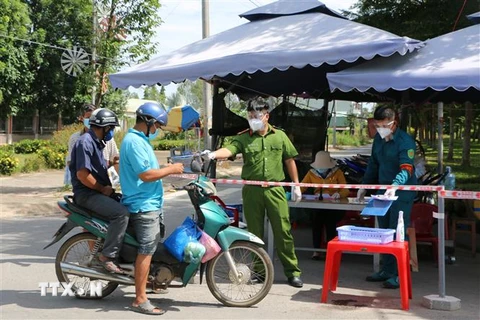 Lực lượng chức năng làm việc tại chốt kiểm soát phòng, chống dịch COVID-19 tại thị trấn Thạnh Hóa, huyện Thạnh Hóa. (Ảnh: Thanh Bình/TTXVN)