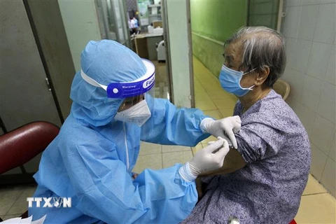 Các y bác sỹ bệnh viện Phú Nhuận thực hiện tiêm vaccine cho người trên 65 tuổi, người có bệnh nền tại Trung tâm y tế phường 11, quận Phú Nhuận, TP.HCM. (Ảnh minh họa: Thanh Vũ/TTXVN)