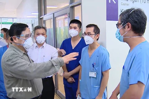 Thủ tướng Chính phủ Phạm Minh Chính, Trưởng Ban chỉ đạo Quốc gia phòng, chống dịch COVID-19 thăm hỏi động viện đội ngũ y bác sỹ tại Bệnh viện hồi sức cấp cứu Bình Dương. (Ảnh: TTXVN)