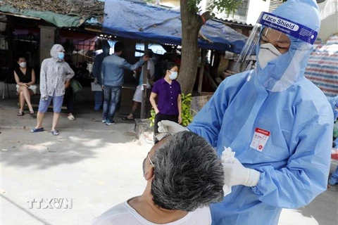 Nhân viên y tế lấy mẫu xét nghiệm cho người dân phường Thổ Quan, quận Đống Đa. (Ảnh: Trần Việt/TTXVN)