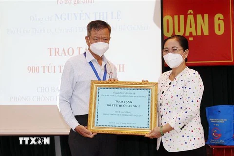  Bà Nguyễn Thị Lệ, Chủ tịch HĐND Thành phố Hồ Chí Minh thay mặt Thường trực HĐND Thành phố trao tặng 900 túi thuốc hỗ trợ gia đình cho Ban Chỉ đạo phòng, chống dịch COVID-19 quận 6. (Ảnh: Xuân Khu/TTXVN)