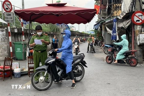 Lực lượng công an kiểm tra giấy tờ của người dân tại chốt cửa khẩu Hàm Tử Quan. (Ảnh: Văn Cảnh/TTXVN)