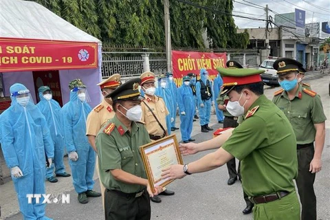 Thứ trưởng Lê Quốc Hùng trao bằng khen của Bộ trưởng Bộ Công an cho Đại tá Trần Tiến Đạt, Phó Giám đốc Công an tỉnh Đồng Nai. (Ảnh: TTXVN phát)