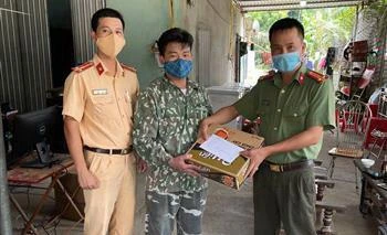 Cán bộ chiến sỹ chốt kiểm dịch Sơn Nam tặng anh Minh mỳ tôm và 500.000 đồng. (Ảnh: TTXVN phát)
