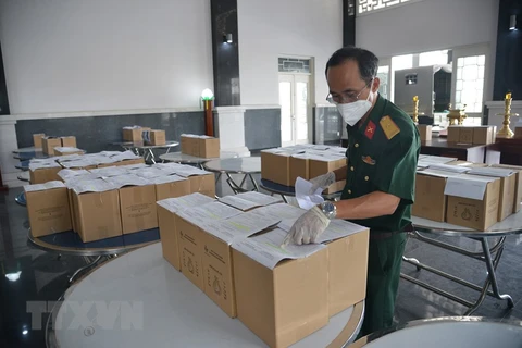 Các cán bộ Bộ Tư lệnh TP Hồ Chí Minh kiểm tra tro cốt người mắc bệnh COVID-19 tử vong tại Nhà tang lễ Thành phố Hồ Chí Minh trước khi giao về nhà cho thân nhân. (Ảnh: Mạnh Linh/TTXVN)