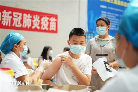 Nhân viên y tế tiêm vaccine ngừa COVID-19 cho học sinh tại Quý Châu, Trung Quốc. (Ảnh: THX/TTXVN)