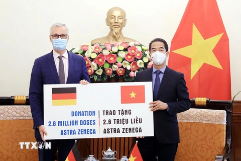Thứ trưởng Ngoại giao Tô Anh Dũng tiếp nhận tượng trưng 2,6 triệu liều vaccine AstraZeneca từ Đại sứ Đức tại Việt Nam Guido Hildner. (Ảnh: Lâm Khánh/TTXVN)