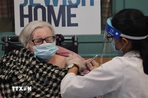 Nhân viên y tế tiêm vaccine phòng COVID-19 của hãng Pfizer cho người cao tuổi. (Ảnh: AFP/TTXVN)